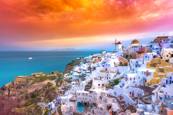 ST Oia town on Santorini island Greece. Traditional and famous houses and churches with blue domes over the Caldera Aegean sea